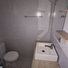 Foto de um banheiro com vaso sanitário e pia brancos.