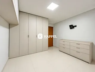 Quarto com armários embutidos brancos e piso claro.