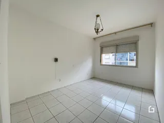 Foto de um ambiente interno com paredes brancas e piso de cerâmica.