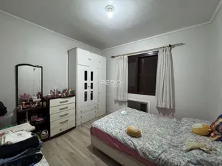 Quarto com armário e cama em ambiente interno.