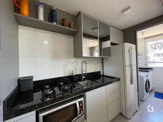 Cozinha moderna com armários cinzas e bancadas escuras.