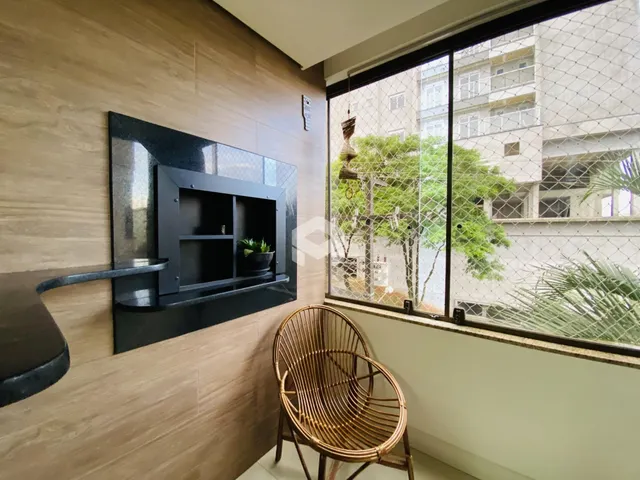 Sala de estar com parede de lareira e grande janela com vista para o exterior.