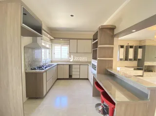 Interior de uma cozinha com armários claros e piso de cerâmica.