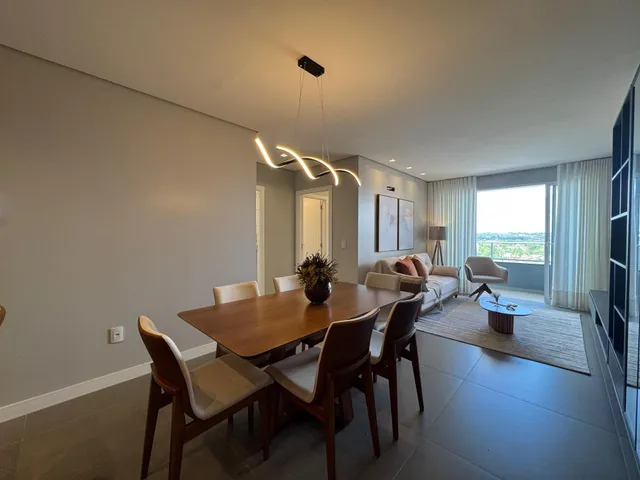 Uma sala de jantar moderna com mesa de madeira e vista da janela.