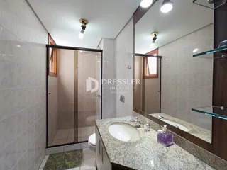 Foto de um banheiro com box de vidro e bancada de granito.