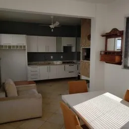 Sala de estar com sofá e armários brancos.