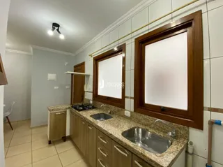 Cozinha com armários de madeira e bancadas de granito.
