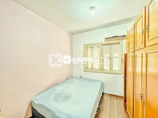 Quarto com cama de casal e piso de madeira.