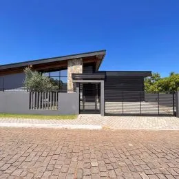 Fachada de uma residência moderna com revestimento de pedra e estrutura escura em Lajeado, Brasil.