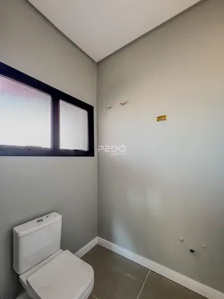 Foto de um ambiente interno de banheiro com paredes cinzas e piso claro.