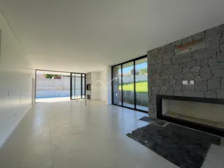 Vista interna de uma sala ampla com piso claro e acesso a área externa.