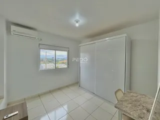 Quarto interno com piso de cerâmica e armário branco.