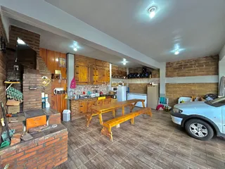 Cozinha com armários de madeira e piso de cerâmica em ambiente de sala.