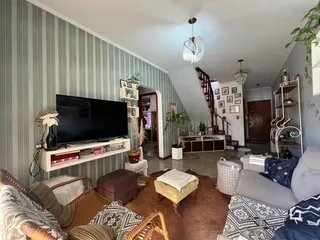 Foto de uma sala de estar com decoração e televisão em um imóvel no Brasil.