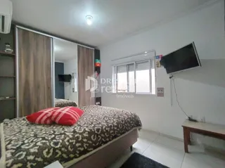 Quarto com cama e painéis de madeira em imóvel no Brasil.