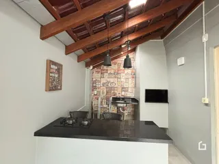 Foto de uma cozinha com teto de madeira e parede decorada.