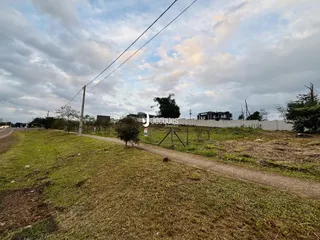 Vista externa de uma propriedade com gramado e caminho de terra em Lajeado.