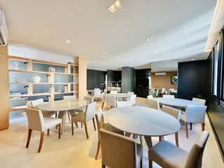 Ambiente interno de uma sala de jantar moderna com mesas redondas.