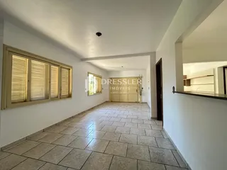 Hall de uma residência com piso de cerâmica e paredes brancas.