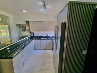 Vista da cozinha moderna com armários e bancadas escuras.