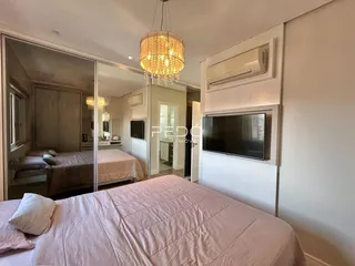 Quarto com cama e espelho em um imóvel no Brasil.