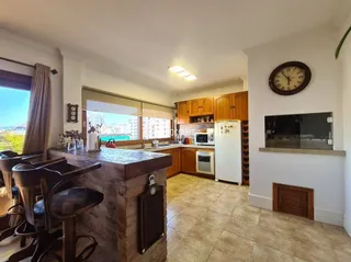 Vista interna de uma cozinha com armários de madeira e ilha.