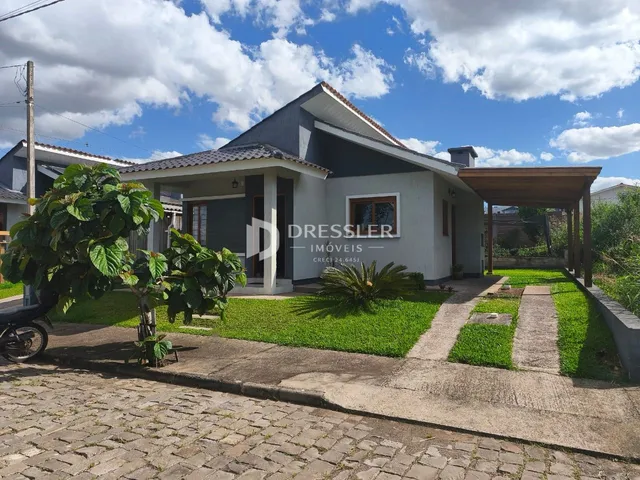 Fachada de uma residência em Lajeado, Brasil, com jardim e área de garagem.