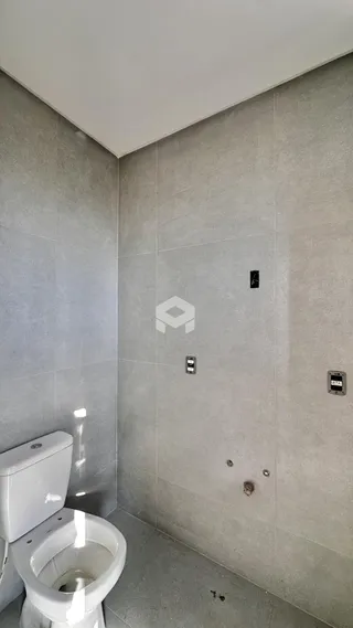 Foto de um banheiro com revestimento de cerâmica e vaso sanitário branco.