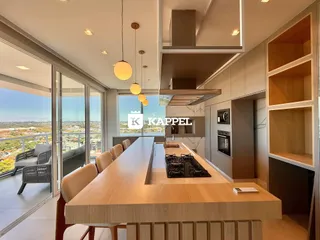 Cozinha moderna com ilha de madeira e vista panorâmica da cidade.
