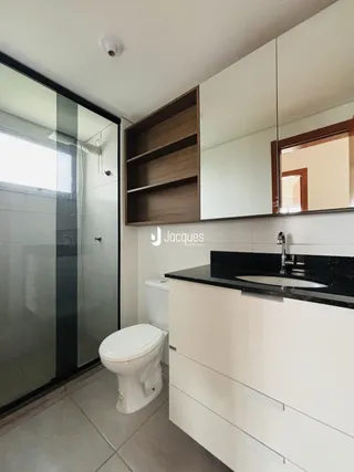 Foto de um banheiro moderno com box de vidro e armário de madeira.