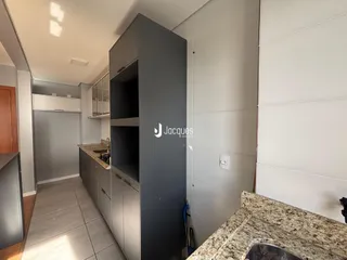 Vista de uma cozinha moderna com armários cinzas e piso de cerâmica.