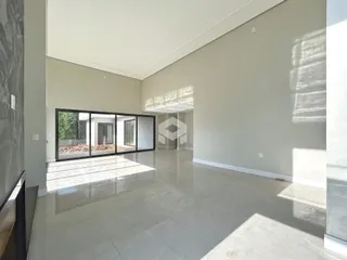 Sala ampla com piso de cerâmica e portas de vidro que dão acesso ao exterior.
