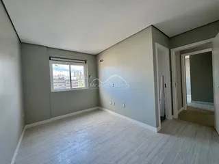 Sala de estar com piso de madeira e janela com vista para a cidade.