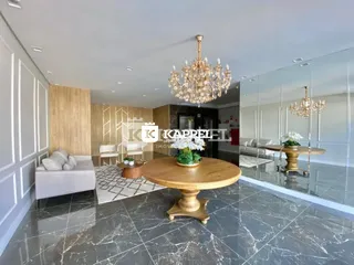 Sala de estar ampla com mesa de centro de madeira e piso em mármore.