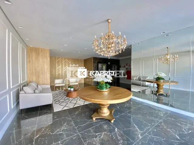 Sala de estar ampla com mesa de centro de madeira e piso em mármore.