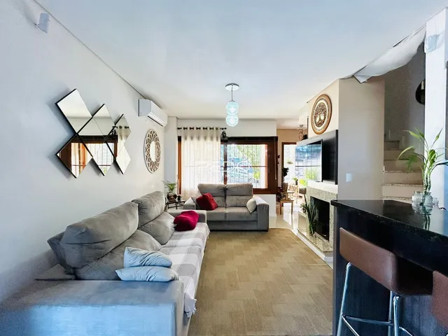 Sala de estar moderna com sofá grande e decoração de parede em Lajeado.