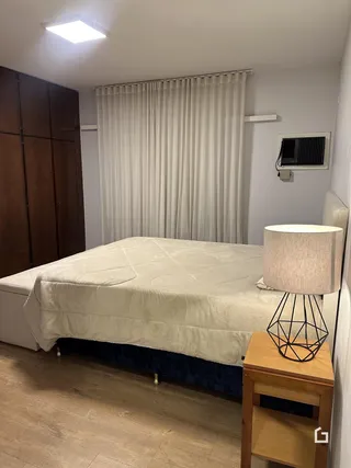 Quarto com cama e armários de madeira em um imóvel.