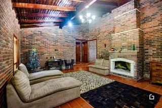 Sala de estar com paredes de tijolo aparente e lareira.