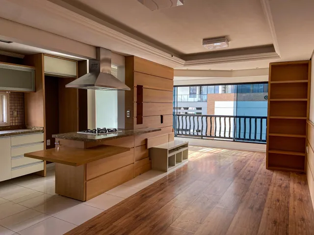 Cozinha moderna com armários de madeira e vista para a varanda.