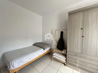 Quarto com cama e armário de madeira na residência.