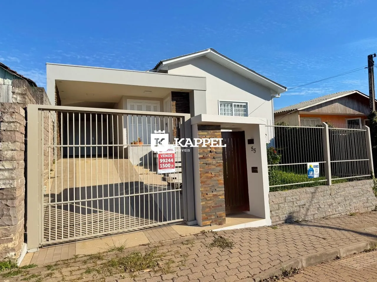 Fachada de uma casa residencial em Lajeado, Brasil, com portão de ferro.