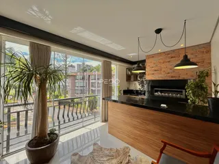 Sala de estar com vista para o exterior e cozinha moderna em Lajeado.