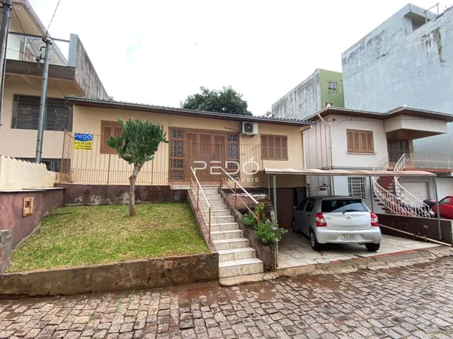 Fachada de uma residência em Lajeado, Brasil, com jardim e acesso por escadas.