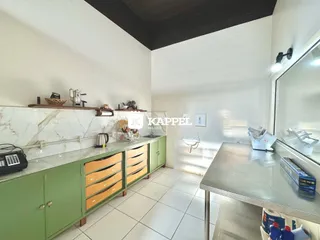 Esta é uma foto de uma cozinha com armários verdes e bancada clara.