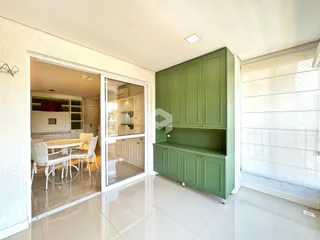 Ambiente interno com armários verdes e piso de cerâmica.