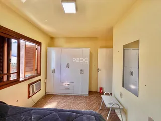 Ambiente interno com armário branco e piso de madeira.