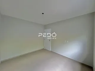 Hall de entrada com paredes brancas e piso claro.