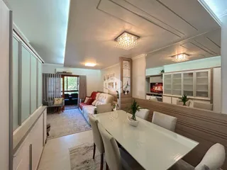 Interior de uma sala de estar com área de jantar e quarto em um imóvel no Brasil.