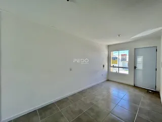Ambiente interno de uma sala com piso de cerâmica e paredes brancas.