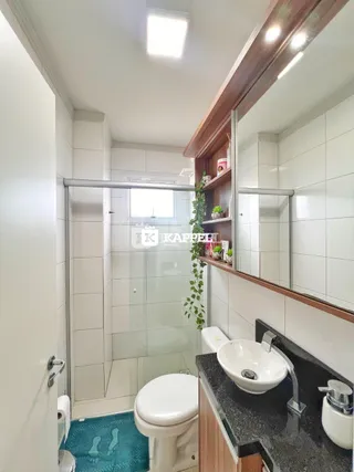 Foto de um banheiro com revestimento branco e bancada escura.